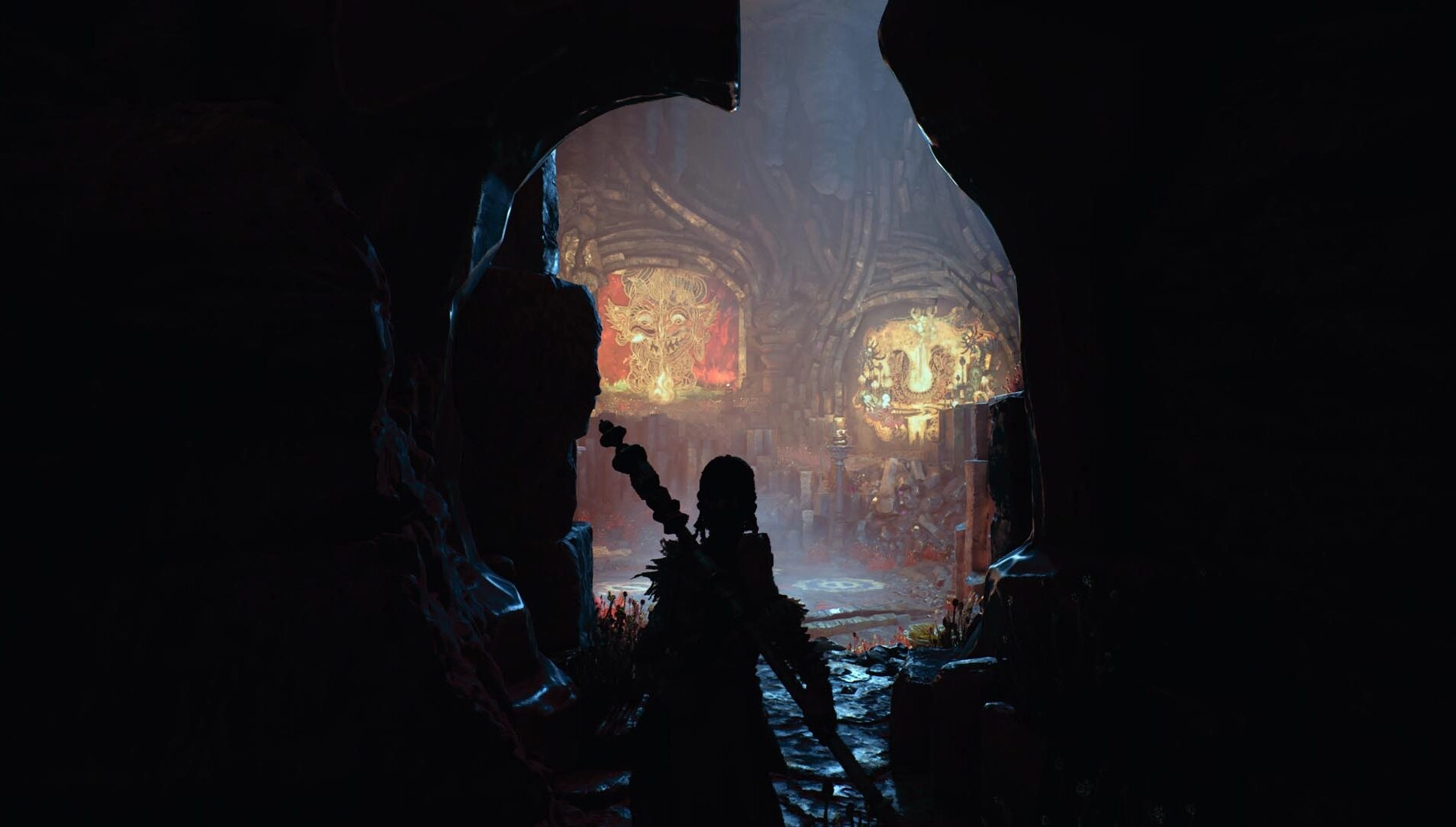 Silhouette of a character in a cave, revealing vibrant ancient artwork, a glimpse into the world of Raji: Kaliyuga game.