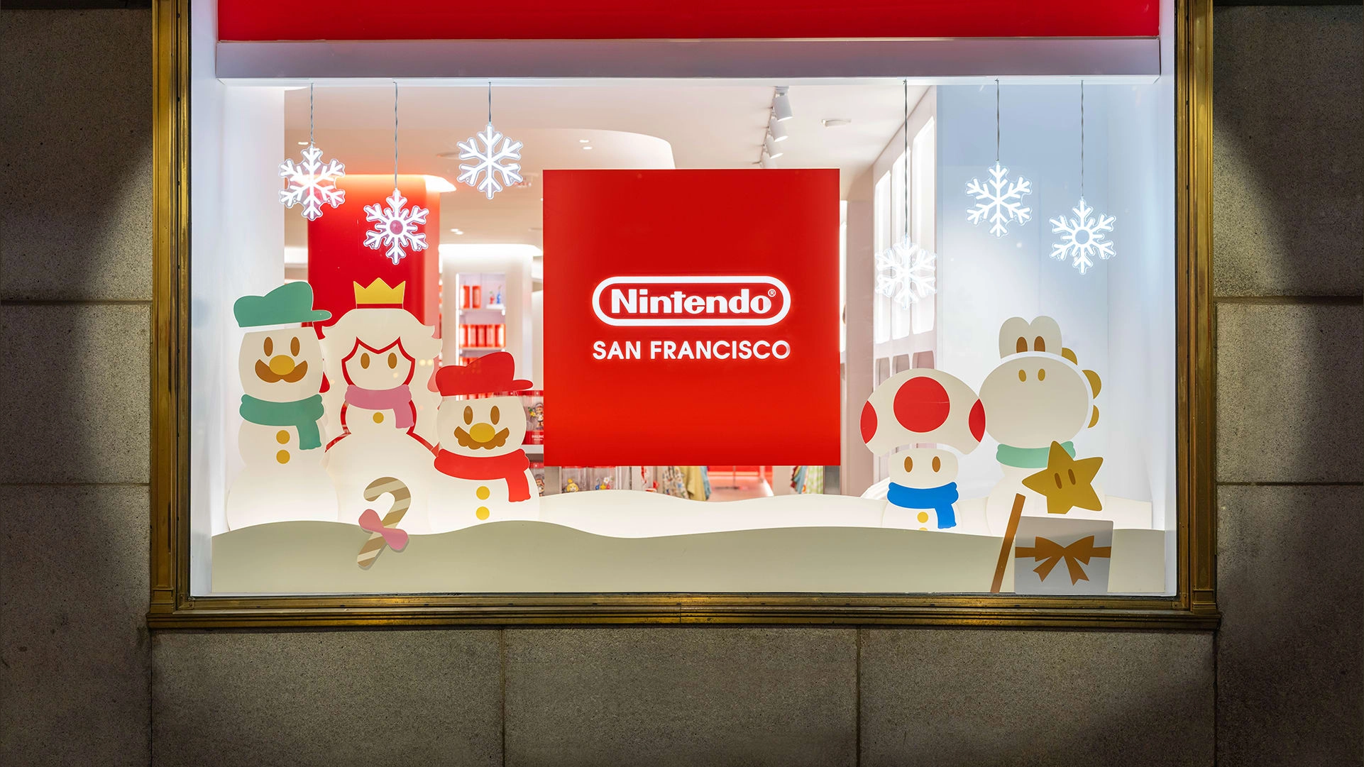Holiday window display at Nintendo SAN FRANCISCO featuring snowmen and festive characters, celebrating the winter season.
