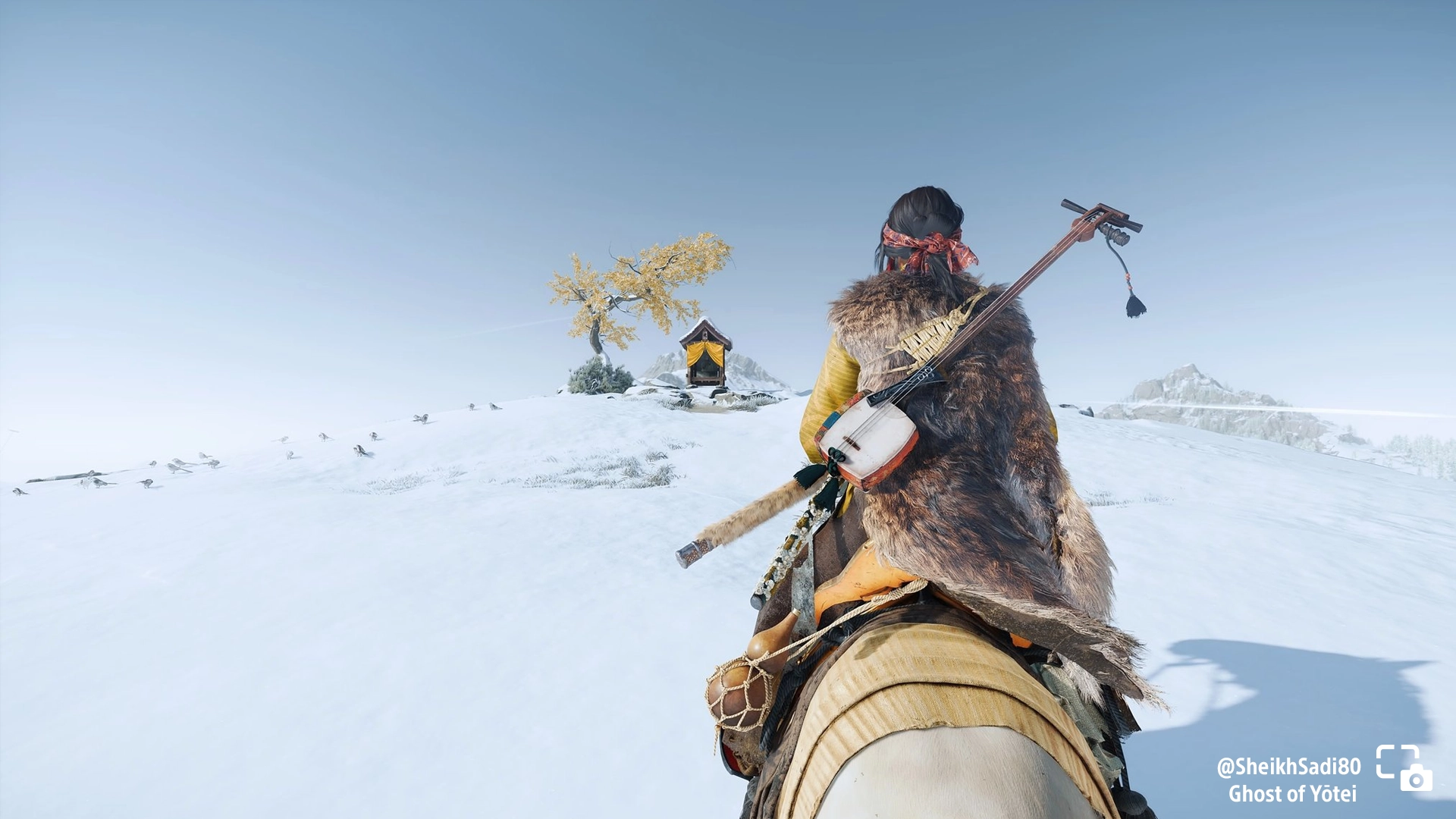 Atsu rides to a shrine on a snowy hill in Ghost of Yōtei, showcasing a serene winter landscape. #PSshare #PSBlog