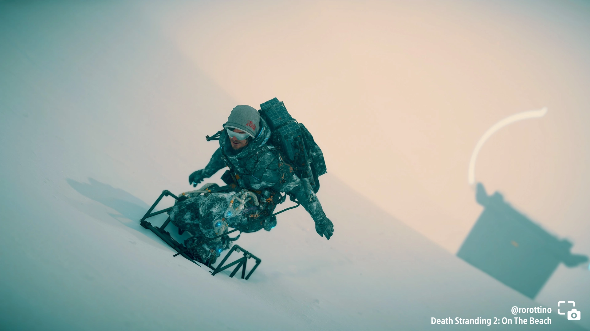 A character snowboards down a snowy slope in Death Stranding 2, showcasing winter gameplay from #PSshare #PSBlog.