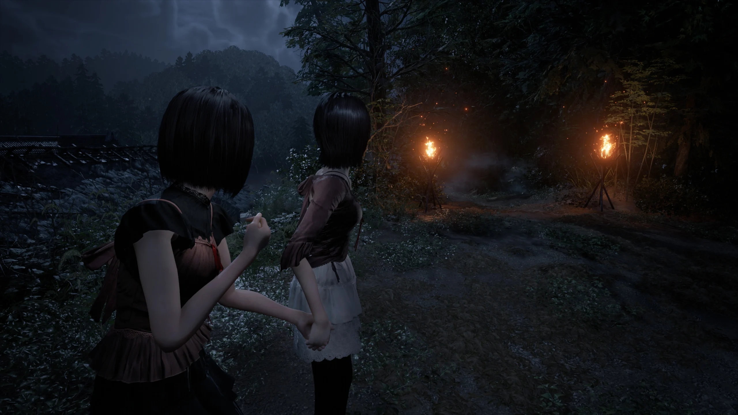 Two characters in a dark forest, holding hands, with eerie torches lighting the path ahead