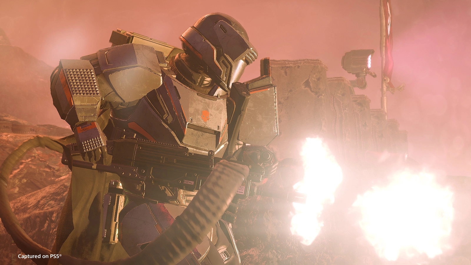 A heavily armored soldier fires a weapon amidst a dusty battlefield, preparing to breach enemy defenses