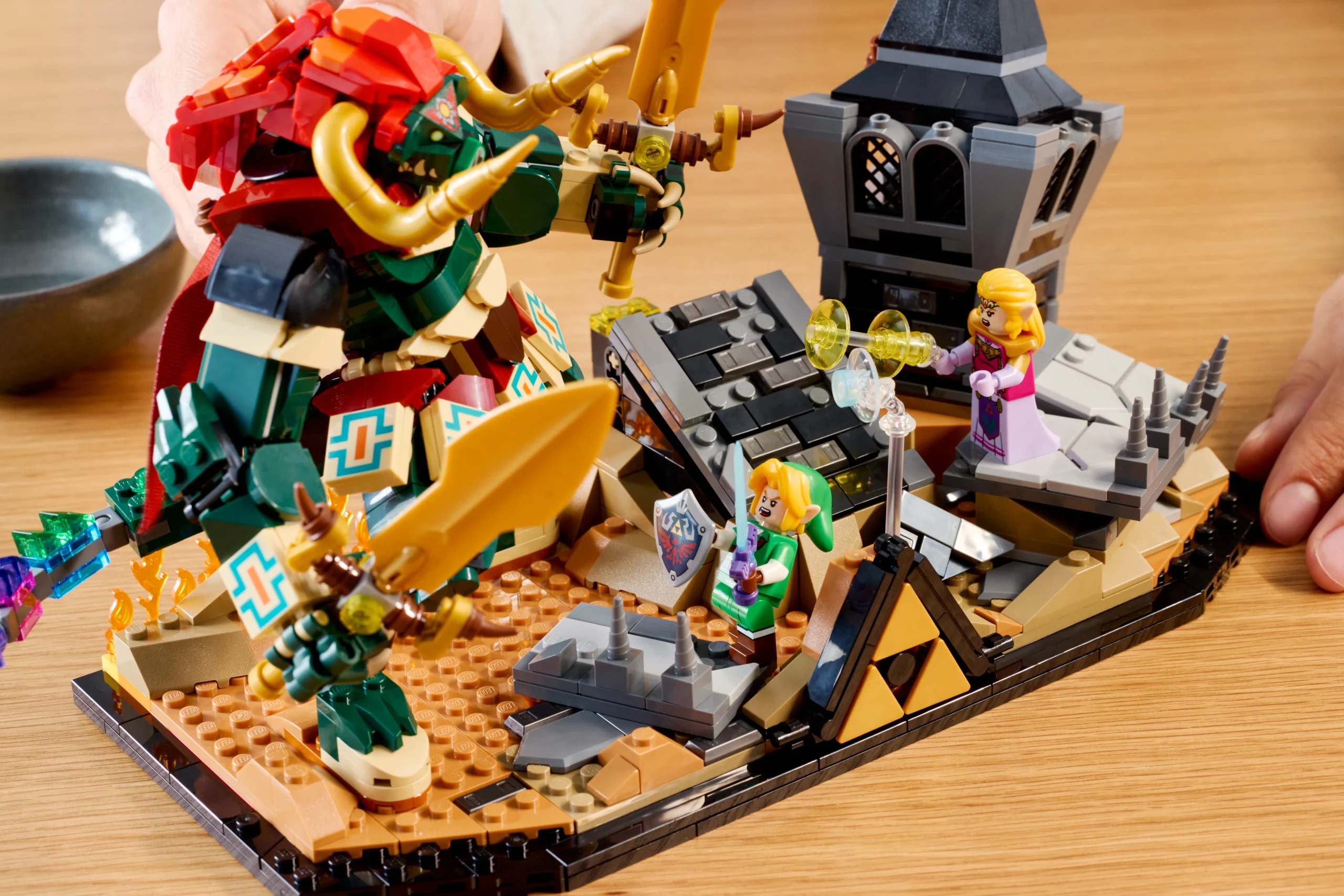 LEGO set depicting Link, Princess Zelda, and Ganon in a battle scene from Ocarina of Time with castle ruins