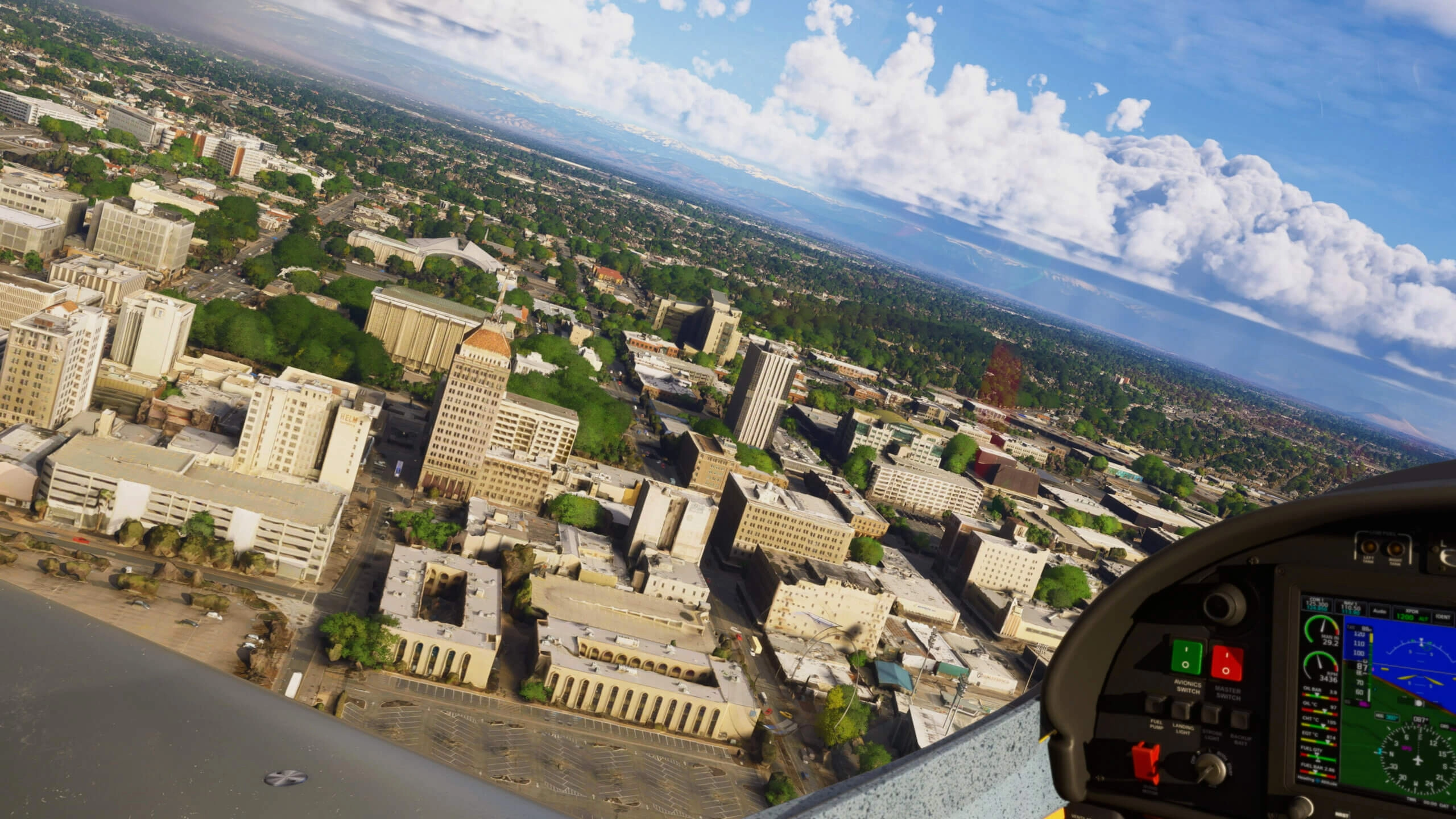 Aerial view of Sacramento's downtown skyline with lush greenery and clear skies, seen from a cockpit perspective