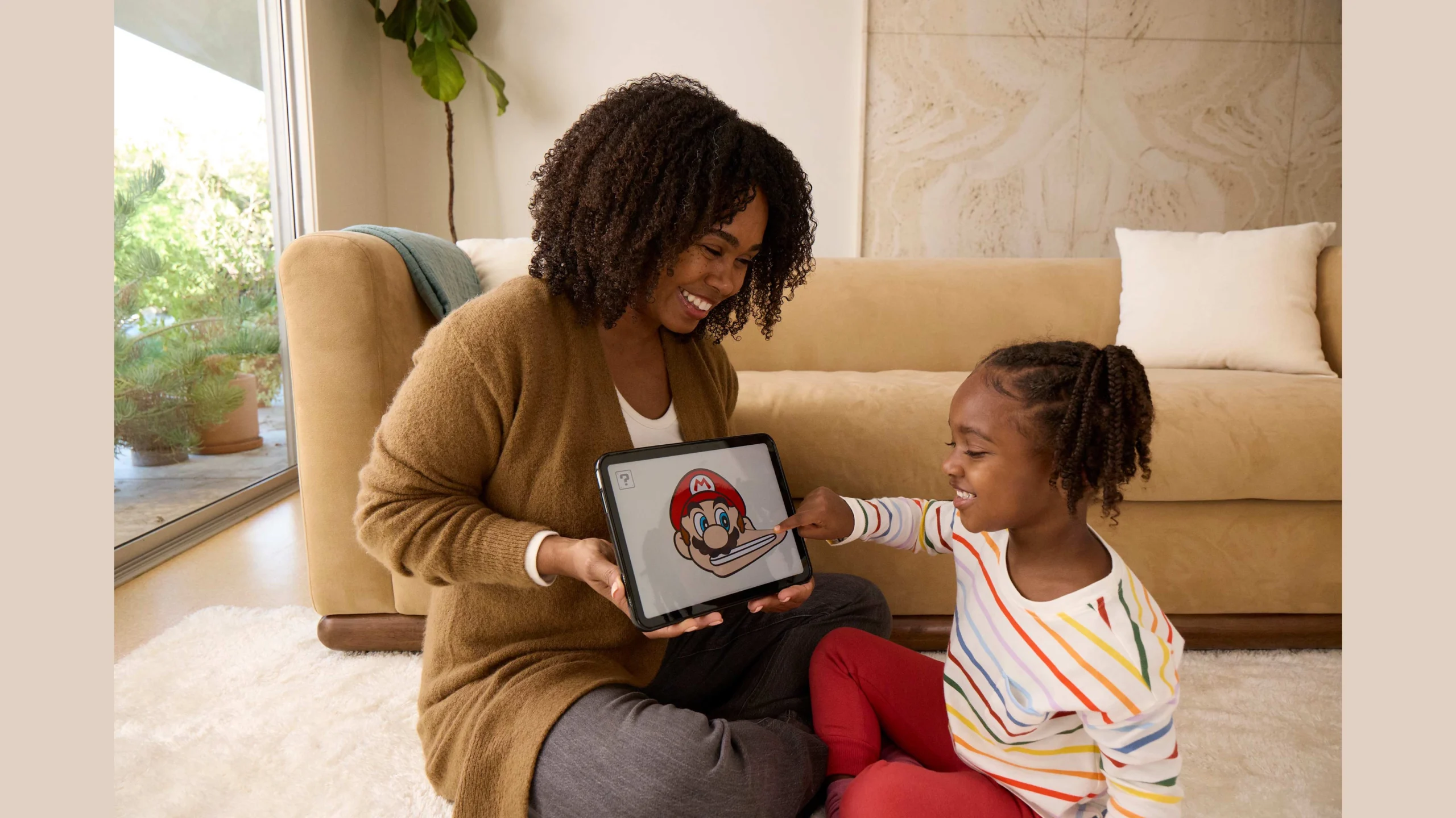 A mother and child enjoying the My Mario™ app together on a tablet, showcasing quality family time and playful learning.