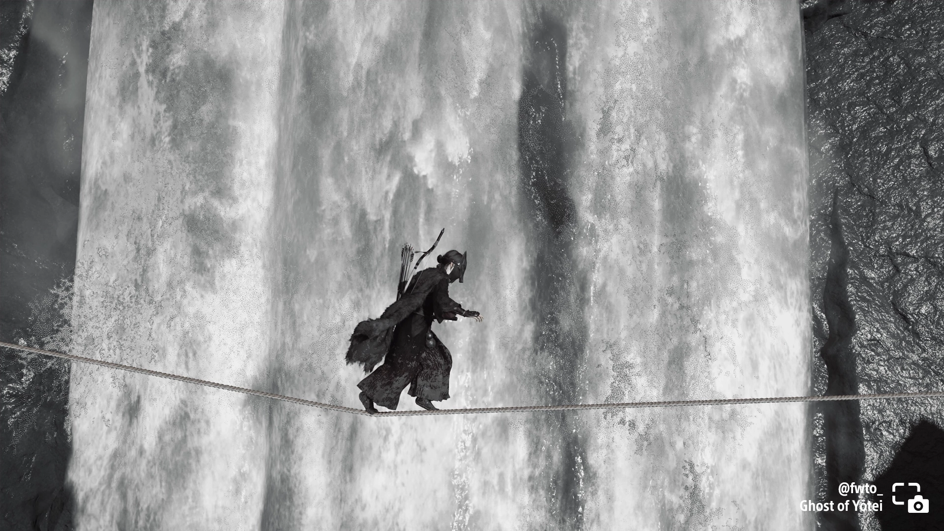 Atsu crosses a rope in front of a majestic waterfall in Ghost of Yōtei, showcasing stunning black and white photography.