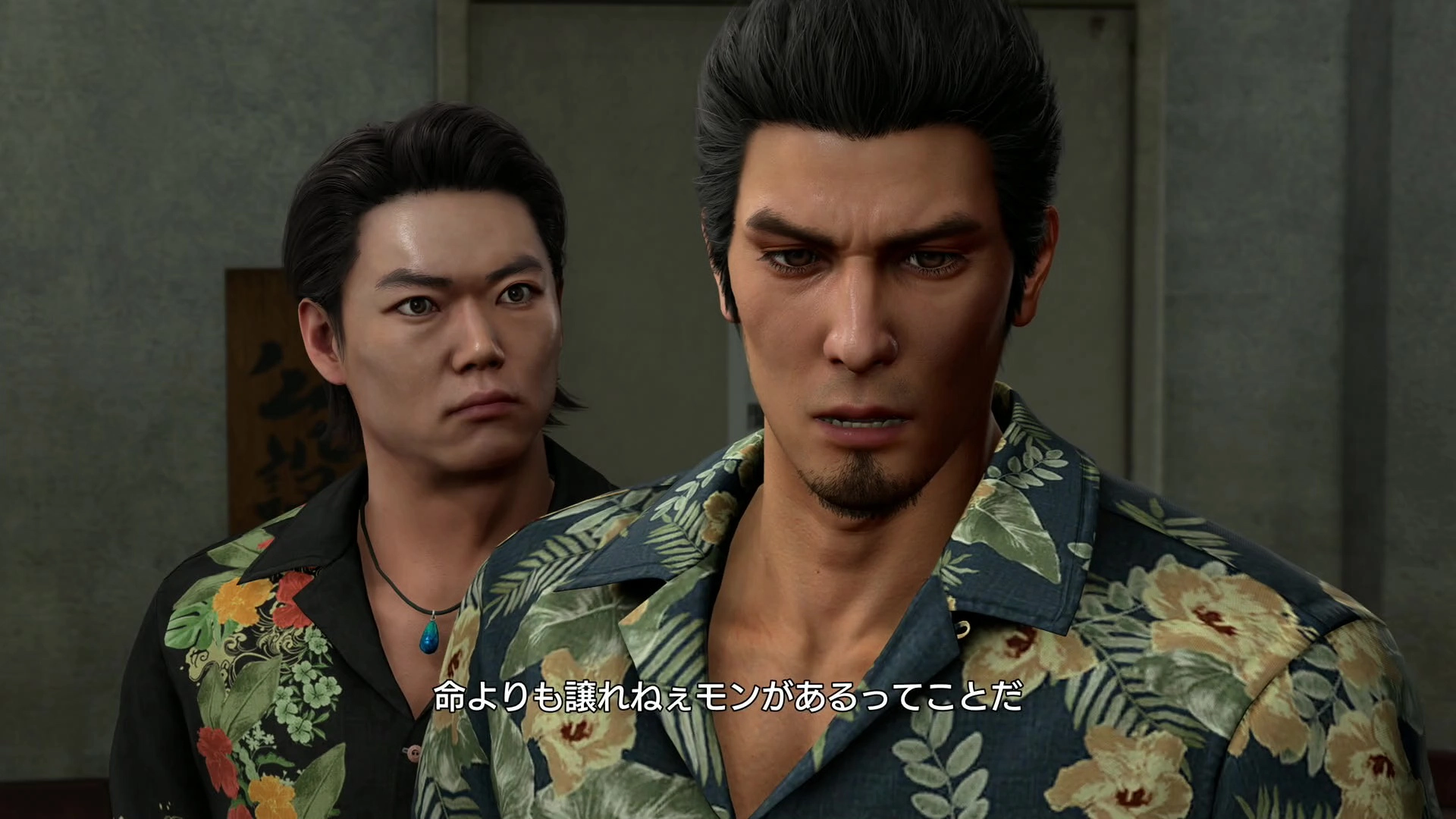 Two men with serious expressions in floral shirts, engaged in a tense moment from Yakuza Kiwami 3 game