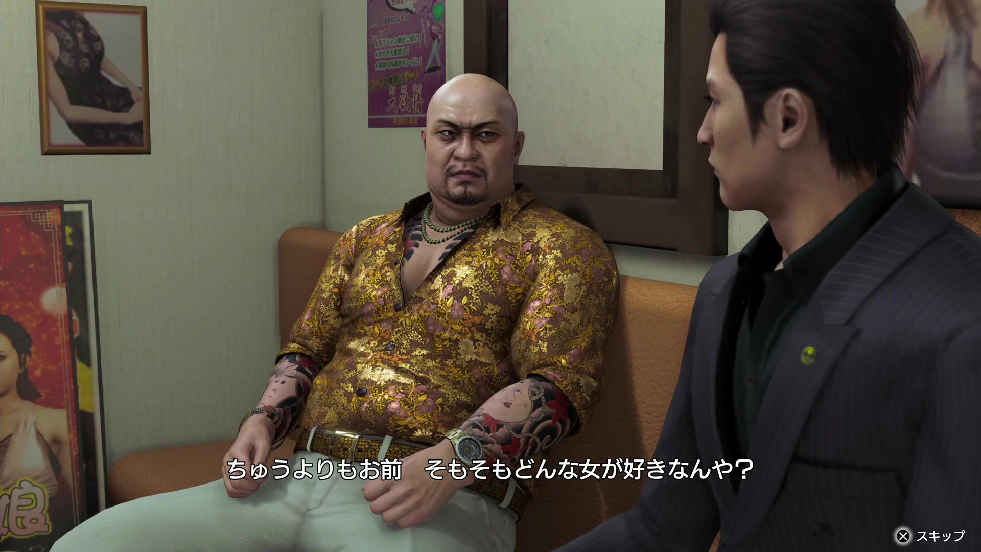 Two characters in a tense conversation on a couch, one in a floral shirt, from Yakuza Kiwami 3 game scene