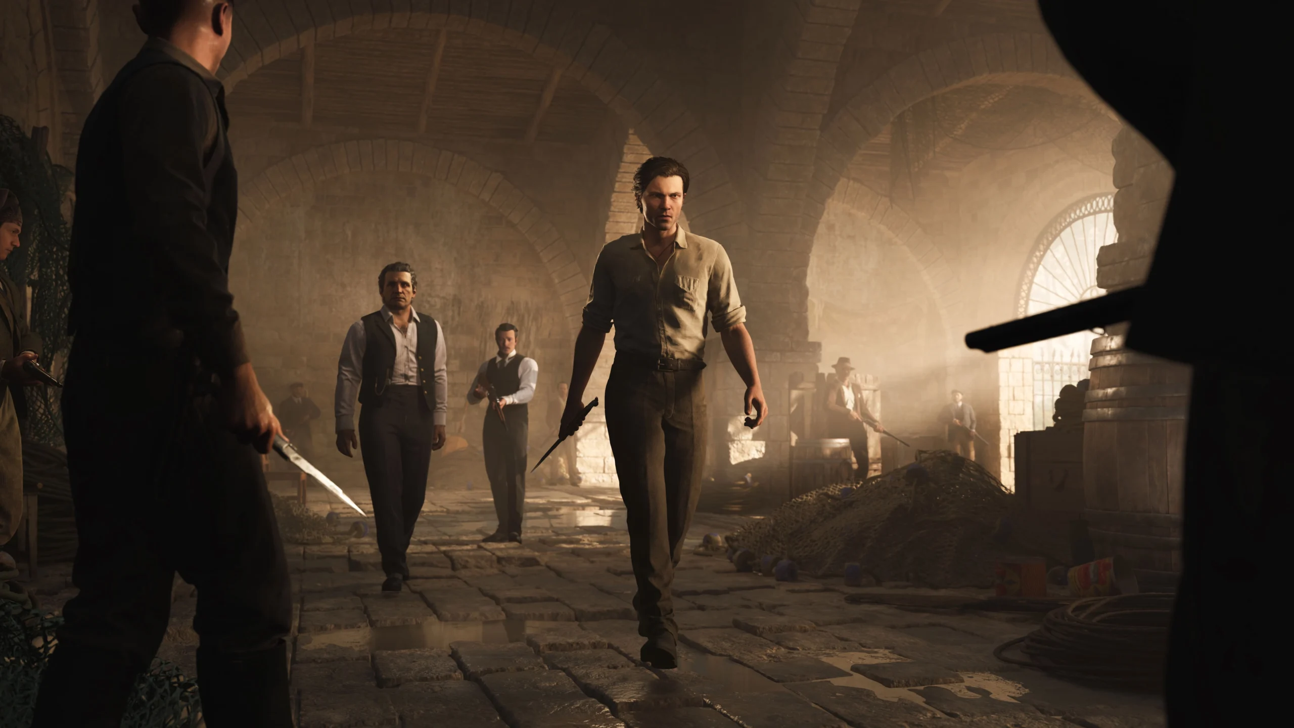 Men in vintage attire walk through a dimly lit, arched stone cellar, exuding a tense, dramatic atmosphere