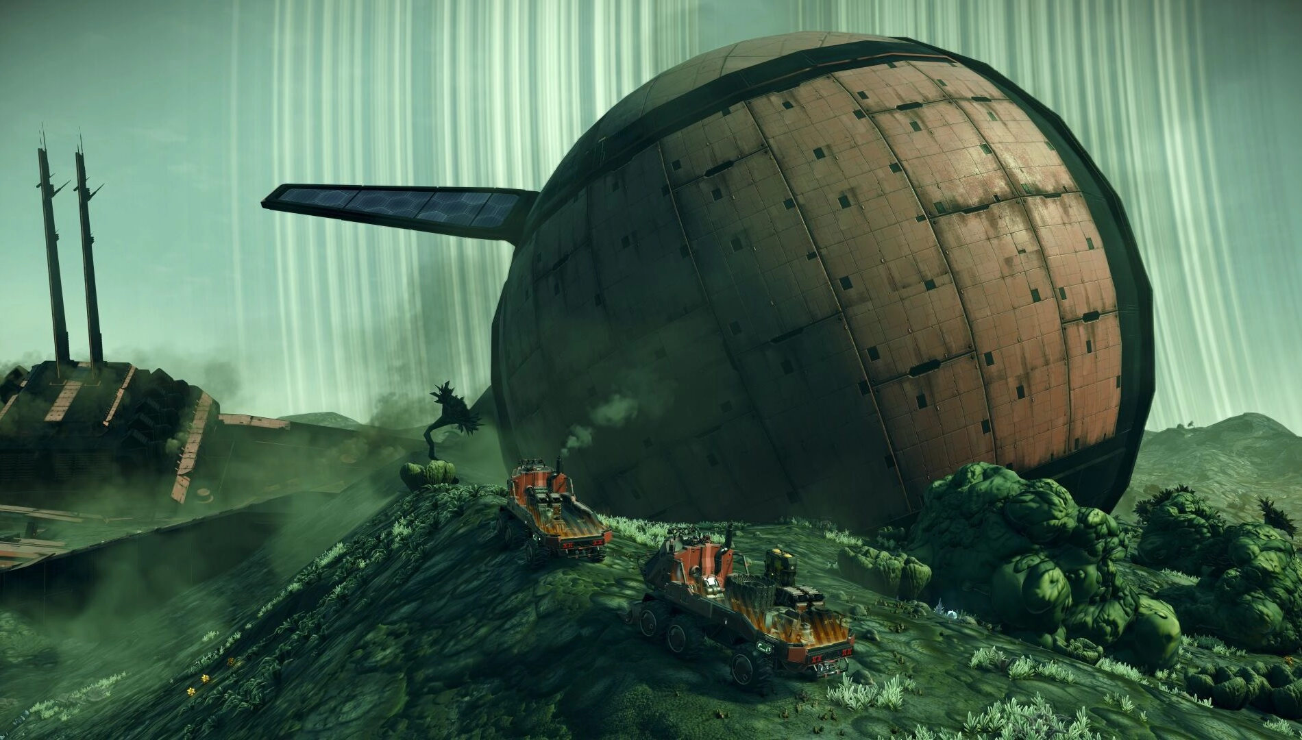 Two vehicles traverse a lush alien landscape with a massive spherical structure in the background