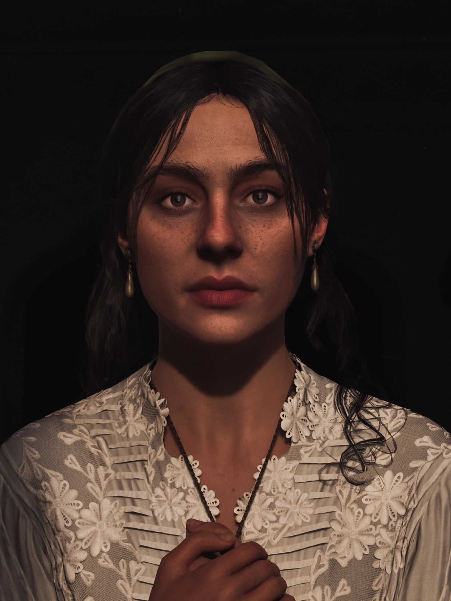 Woman with dark hair and lace dress holding a necklace, set against a dark background