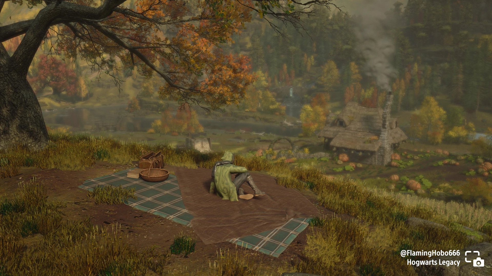 A wizard enjoys a picnic on a blanket near a pumpkin patch with a rustic cabin in the background in Hogwarts Legacy